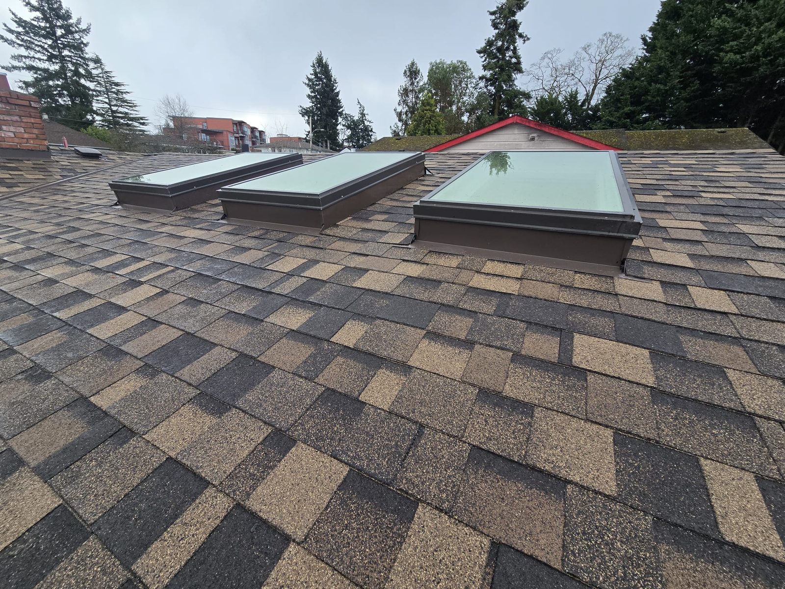 Three skylights with new flashing set into brown shingles